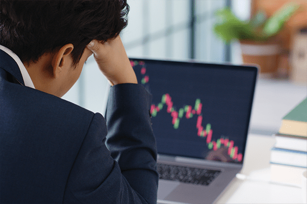 Marketing professional looking frustrated staring at graph with downward trend.